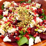 Close up of spinach and beet salad in a wood bowl