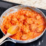 Marinara and meatballs in a pan on a stovetop