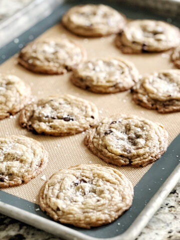 Brown butter chocolate chip cookies on a sheet pan on a counter