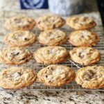 Brown butter chocolate chip cookies on a cooling rack on a countertop