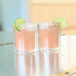 Two blood orange margaritas on a silver table