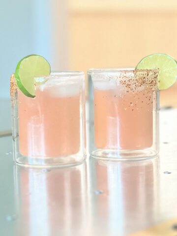 Two blood orange margaritas on a silver table