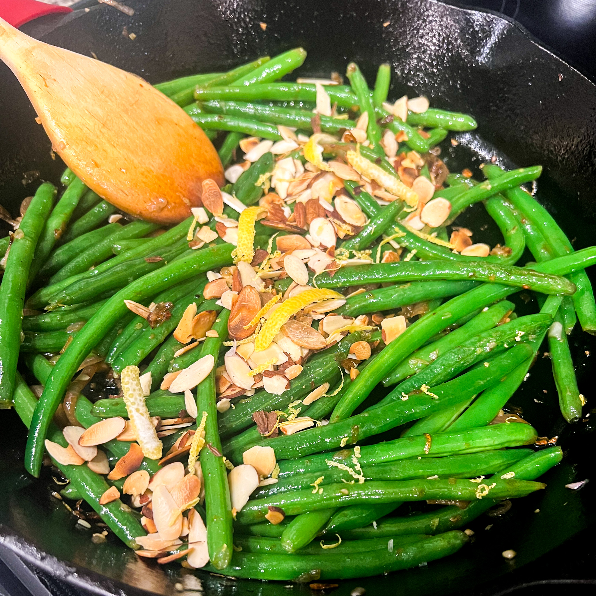 Sautéed green beans with almonds and a garlic lemon sauce in a skillet