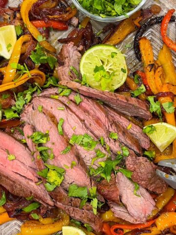 Flank steak fajitas on a sheet pan.